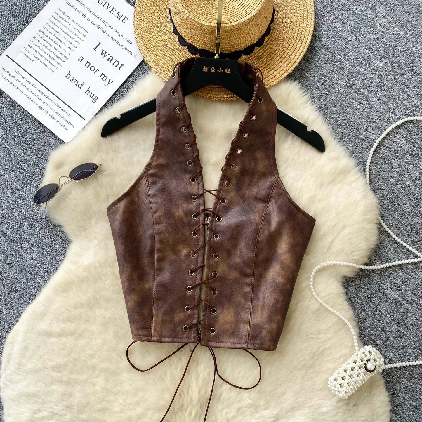 Chic black PU leather crop top with rope straps and hollow-out design, featuring a fitted silhouette and super-short length.