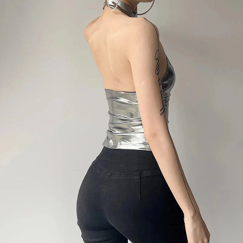 Shiny silver patent leather halter crop top with a backless design and slim fit, perfect for evening wear.