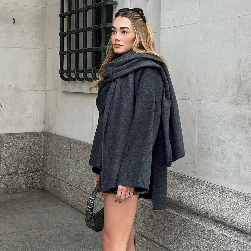 Asymmetric plush jacket with covered button closure and loose fit, made from polyester.