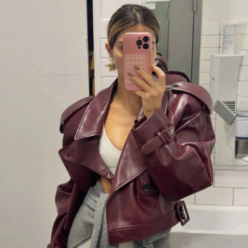 Cropped leather jacket with a single button closure and loose fit, ideal for layering in casual autumn outfits.