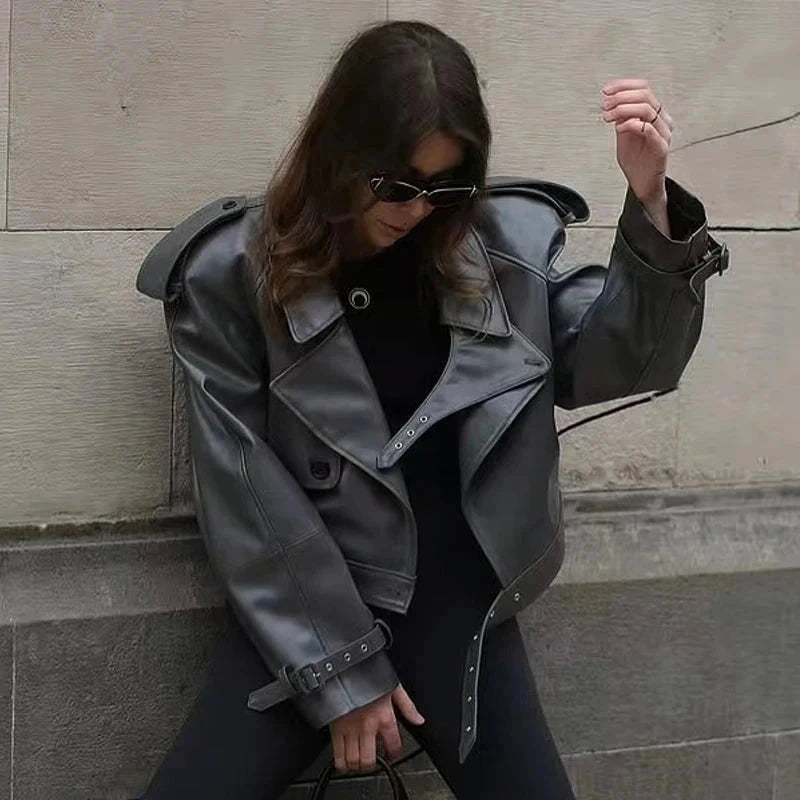 Cropped leather jacket with a single button closure, designed for a loose fit and contemporary style.