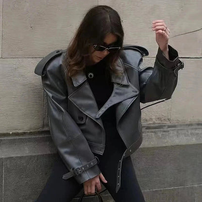 Cropped leather jacket with a single button closure, designed for a loose fit and contemporary style.