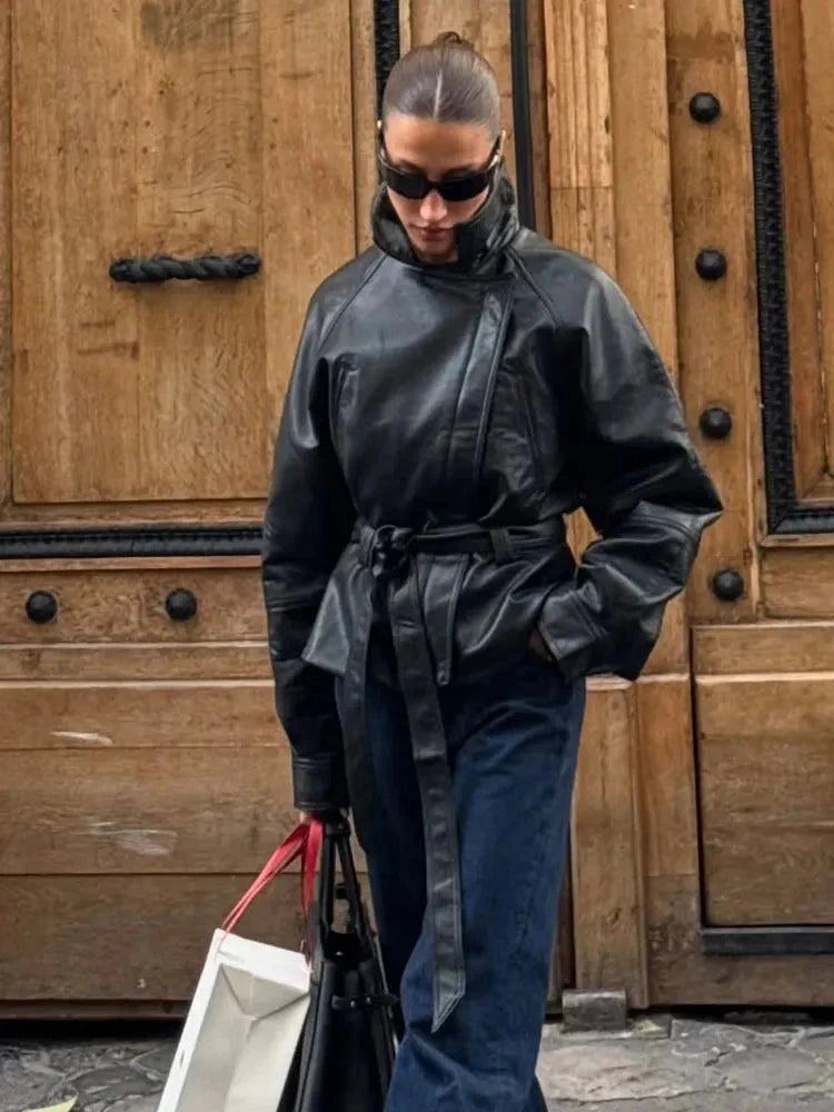 Chic faux leather trench coat with zipper closure and belted waist, designed for modern elegance and layering.