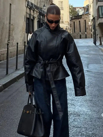 Chic faux leather trench coat with a belted waist and zipper closure, designed for modern elegance and regular fit.