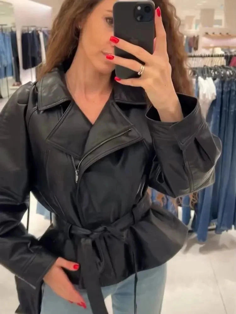 Chic faux leather trench coat with zipper closure and belted waist, designed for modern elegance and layering.