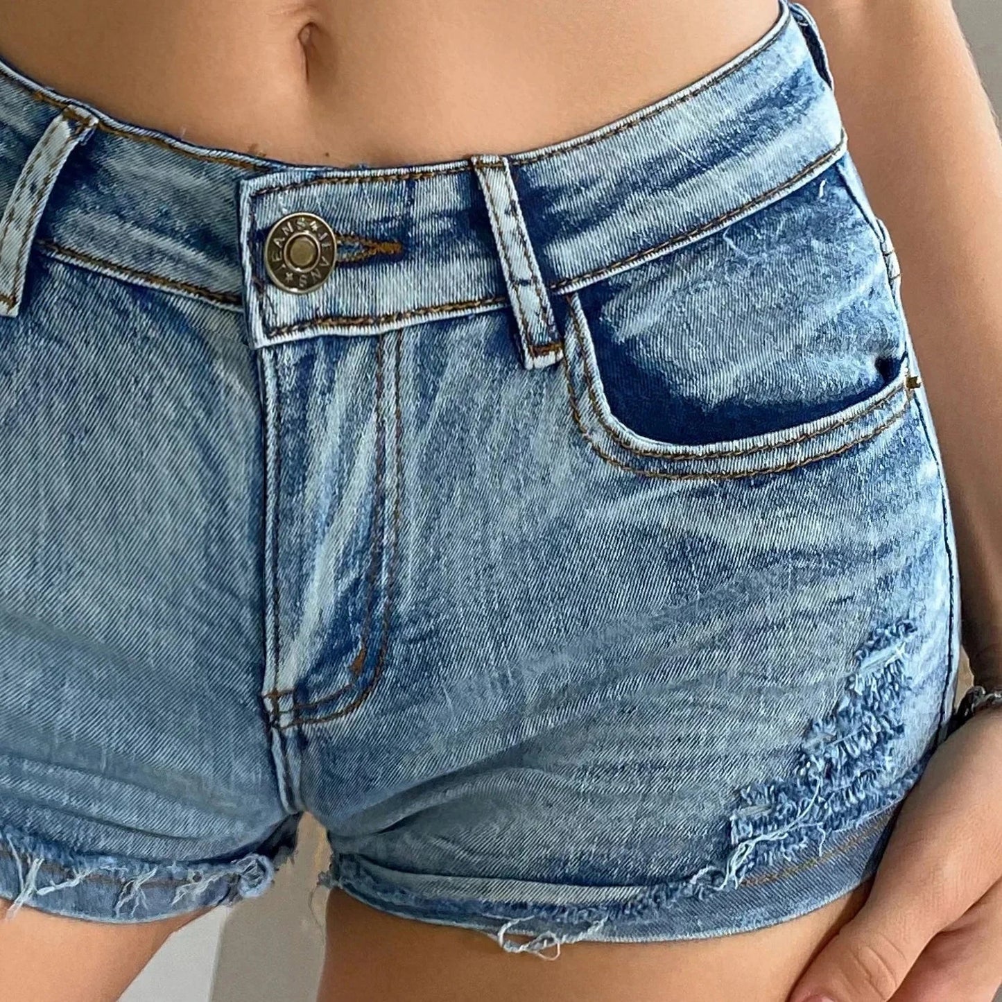 Elevated high-waisted denim shorts with button detail, crafted from a comfortable cotton blend for summer wear.