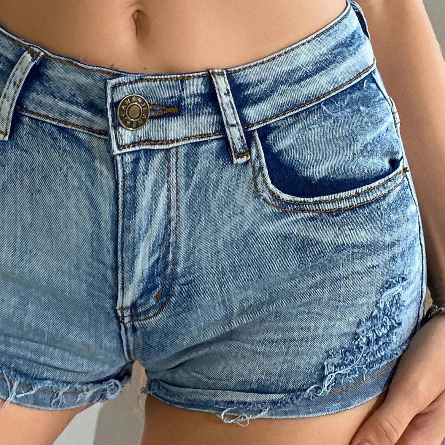 Elevated high-waisted denim shorts with button detail, crafted from a comfortable cotton blend for summer wear.