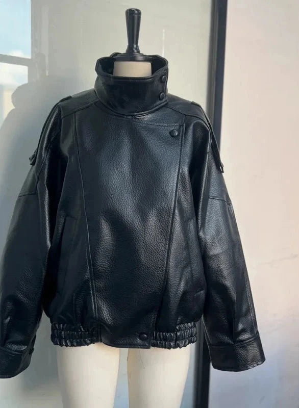 Black loose PU leather jacket with a relaxed fit and zippered front, displayed on a hanger against a neutral background.