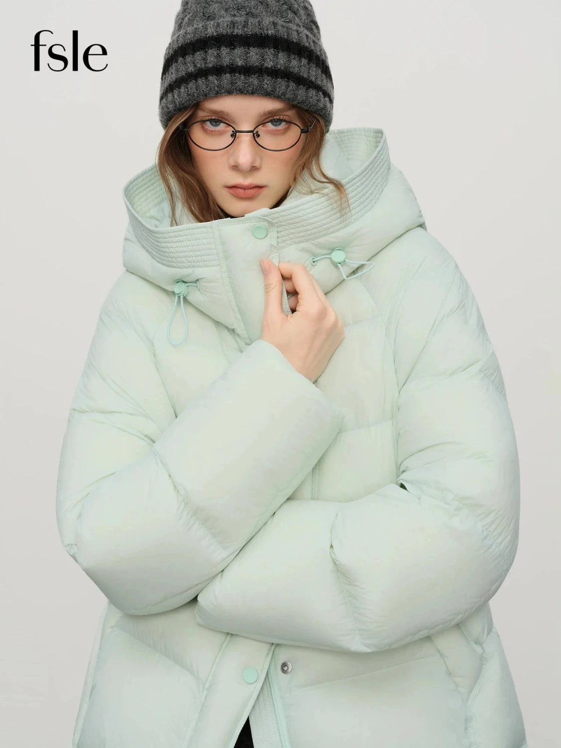 Contemporary short hooded puffer jacket with bat sleeves and duck down filling for warmth and comfort.