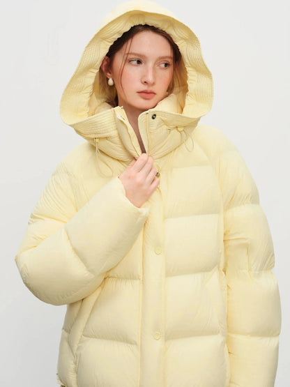 Pale yellow contemporary short hooded puffer jacket with bat sleeves and duck down filling. Regular length and insulated.