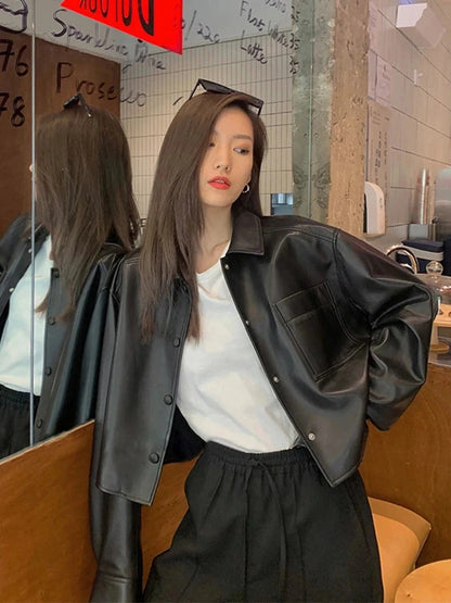 Chic short deep black faux leather jacket with a loose fit, single-breasted design, and functional pockets.