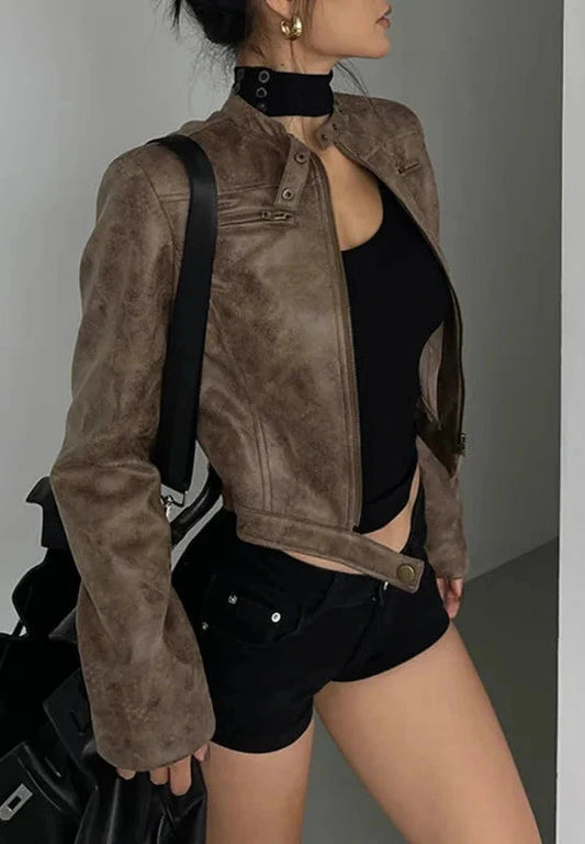 Black stand collar leather jacket with zipper and side pockets displayed on a wooden hanger.