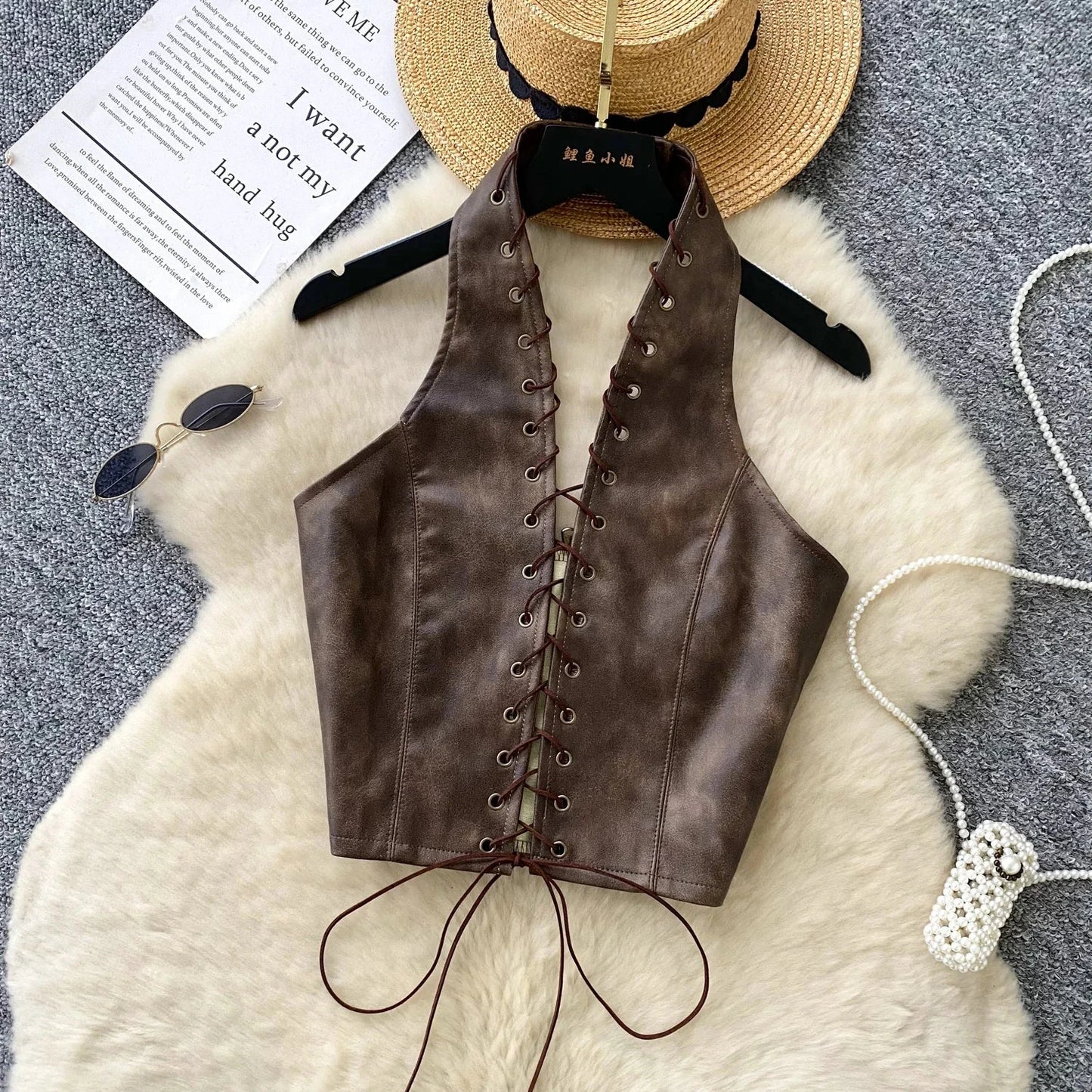 Chic black PU leather crop top with rope straps and hollow-out design, featuring a fitted silhouette and super-short length.