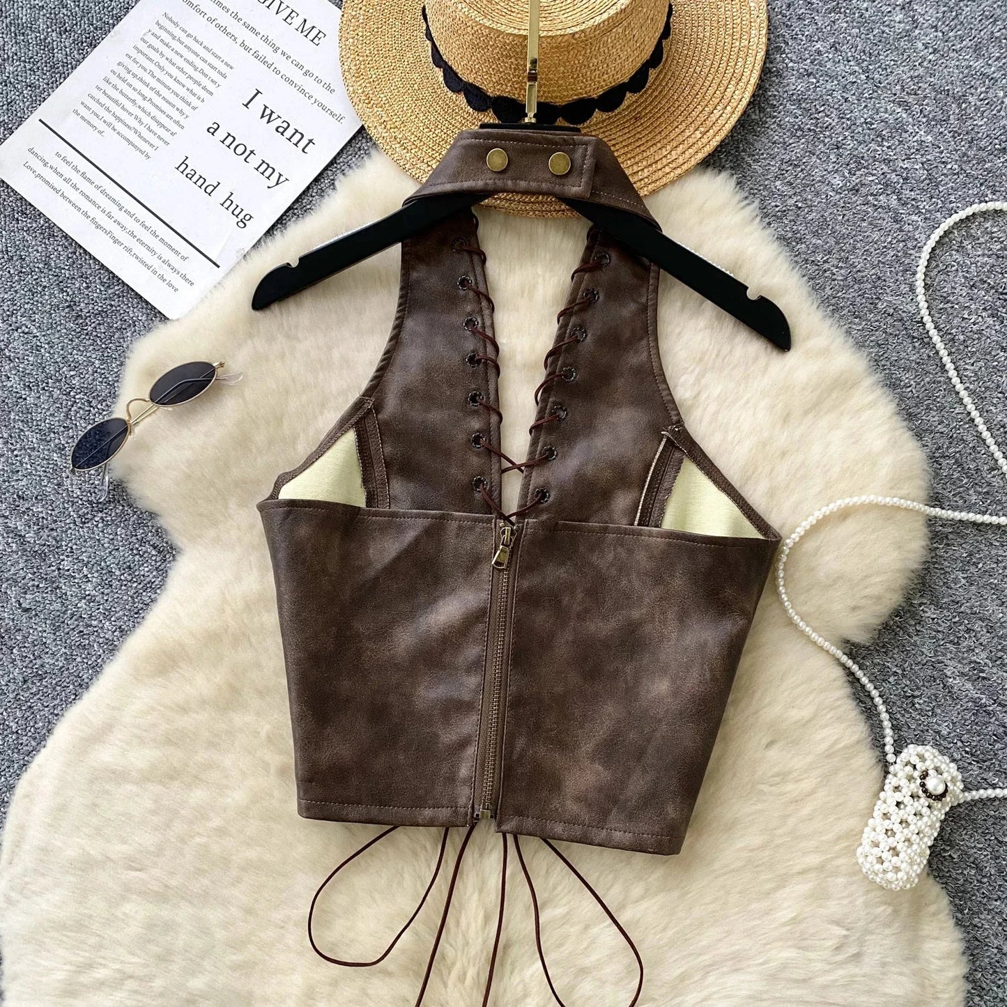 Chic black PU leather crop top with rope straps and hollow-out design, featuring a fitted silhouette and super-short length.