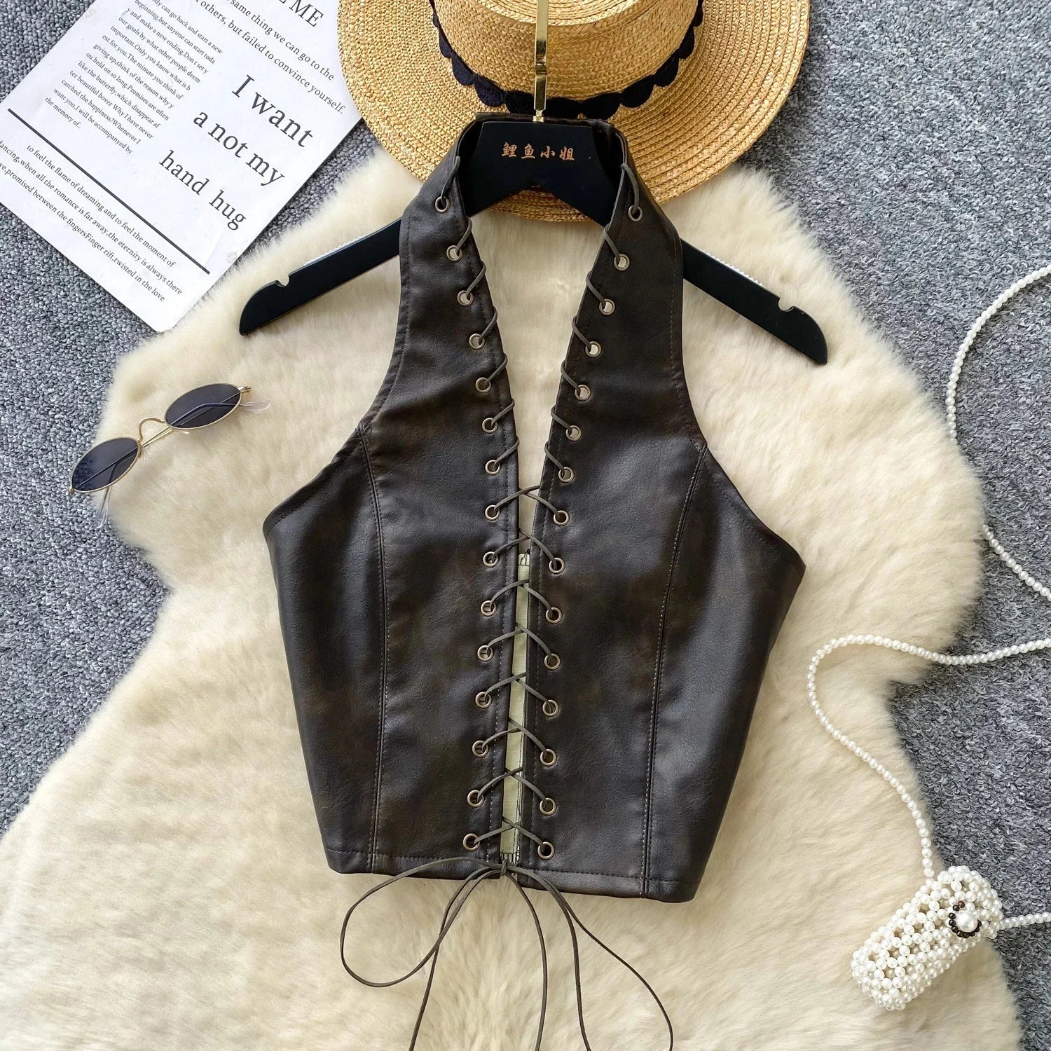 Chic black PU leather crop top with rope straps and hollow-out design, featuring a fitted silhouette and super-short length.