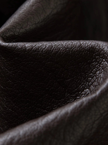 Elegant long overcoat in faux leather with a stand-up collar and belted closure, suitable for casual and formal wear.