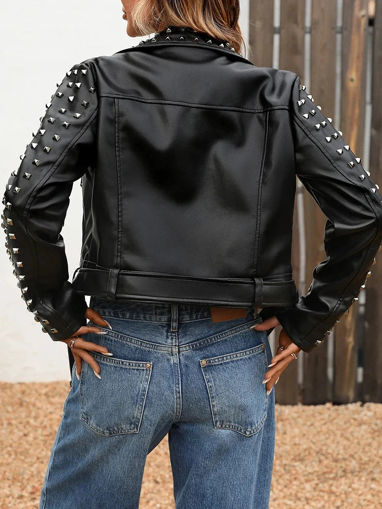 Rivet-embellished black faux leather biker jacket with full sleeves, zipper closure, and turn-down collar.