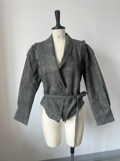 Vintage brown leather jacket with padded shoulders, belt closure, pockets, and turn-down collar. Regular length, tailored fit