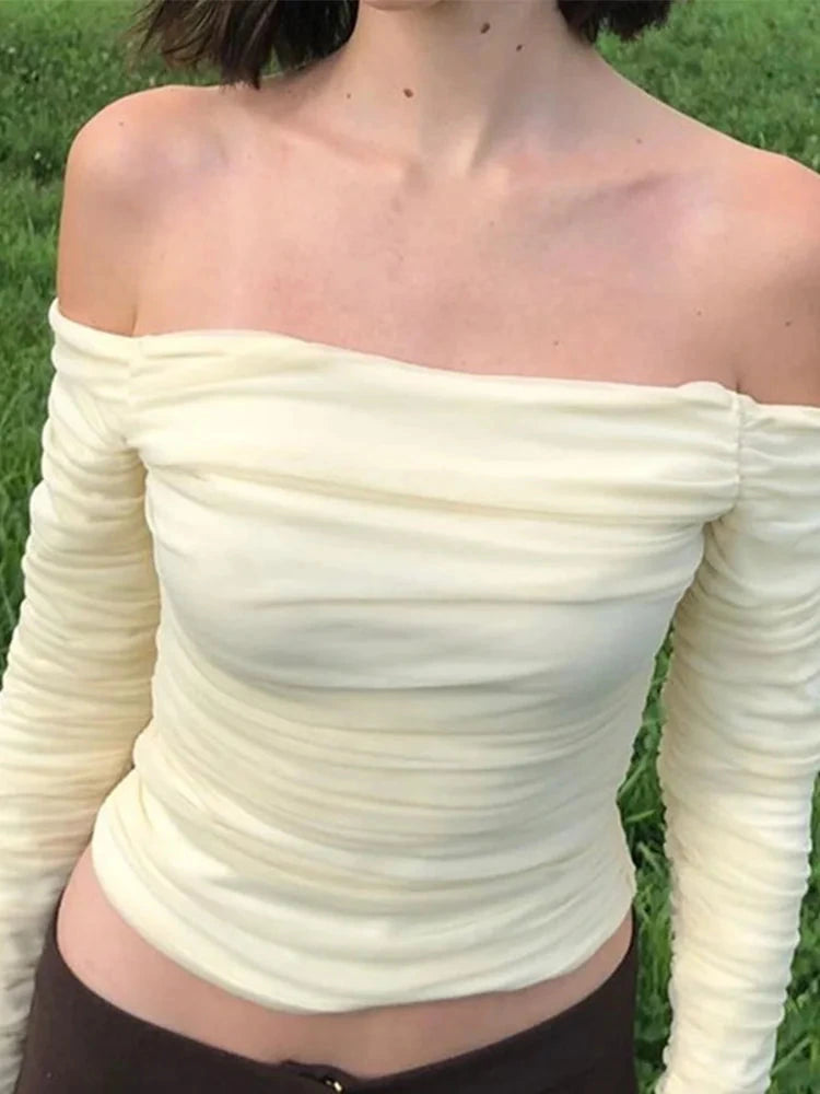 Elegant off-shoulder ruched crop top with mesh detail and full sleeves in a slim fit design.