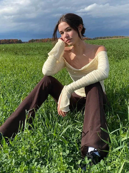 Elegant off-shoulder ruched crop top with mesh detail and full sleeves in a slim fit design.