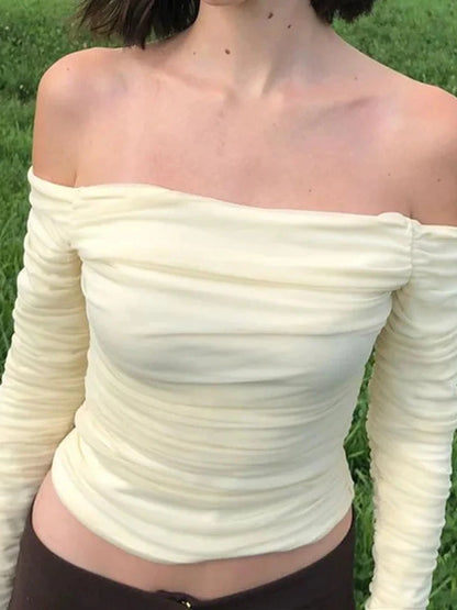 Pale yellow off-shoulder crop top with ruched design and mesh detail, featuring full sleeves and a slim fit.