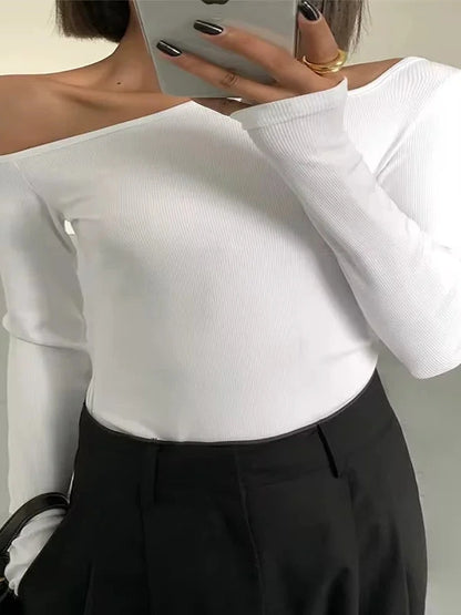 Refined off-shoulder long-sleeved crop top in bright white with skew collar and flare sleeves.