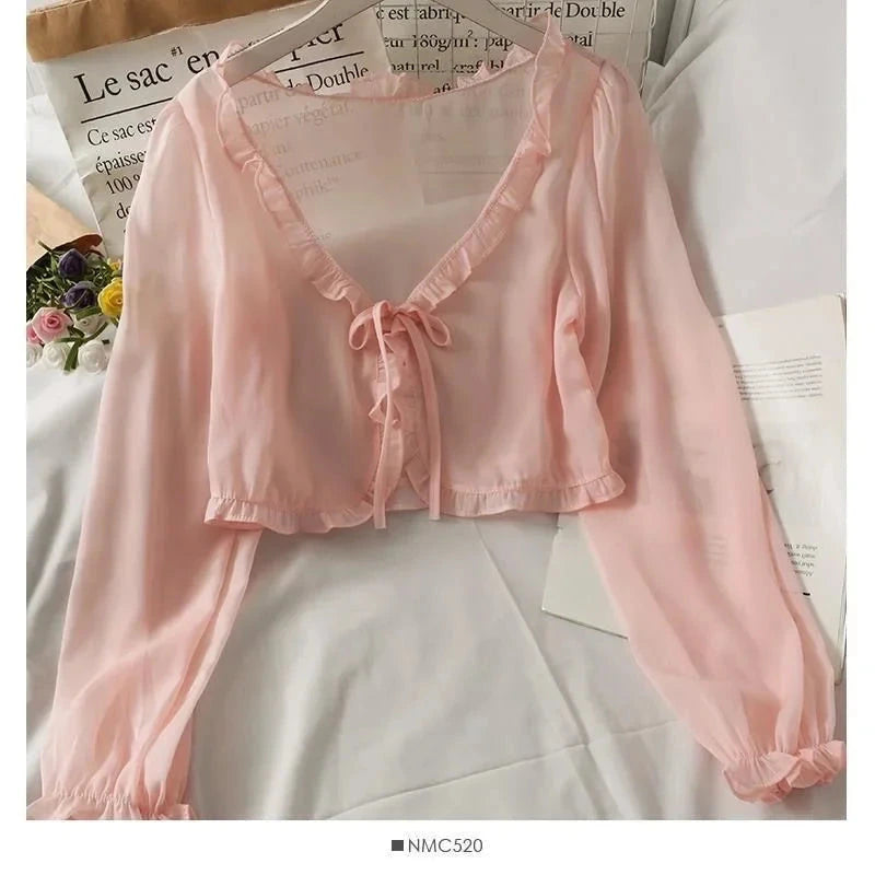 Chic ruffled chiffon cape in soft pink with long sleeves and open stitch design, perfect for layering.