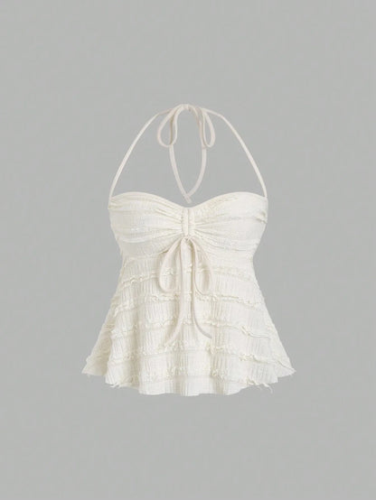 Textured halter neck knitted vest top with drawstring detail and backless design in a soft apricot hue.