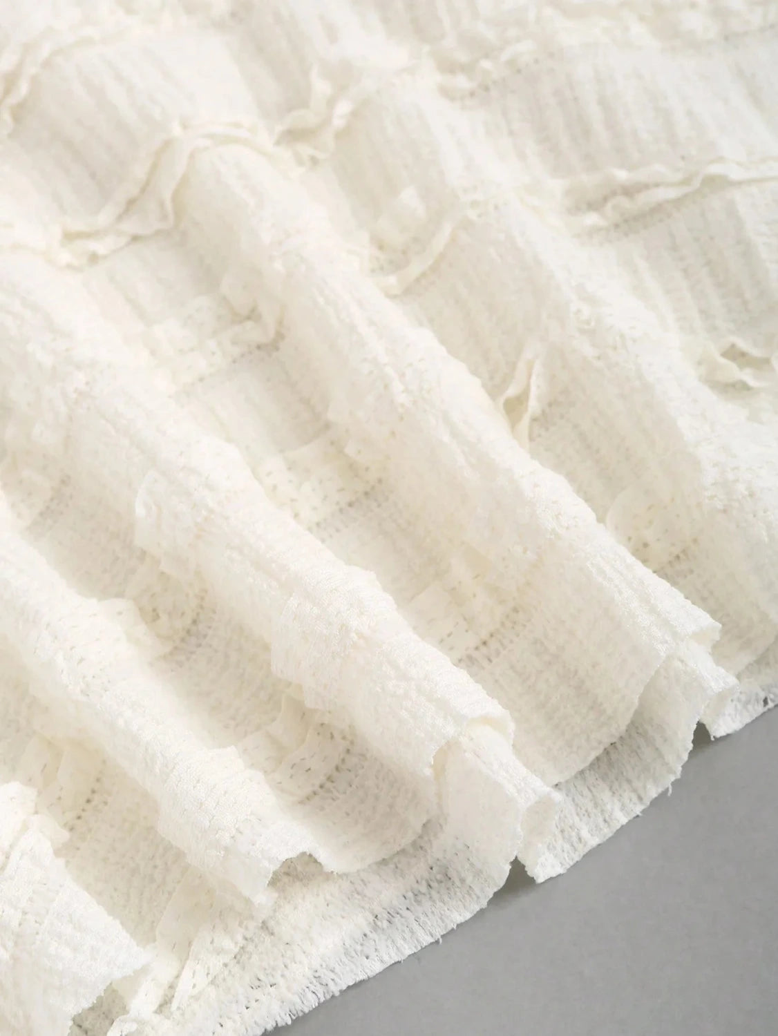 Textured halter neck knitted vest top with drawstring detail and backless design in soft apricot hue.