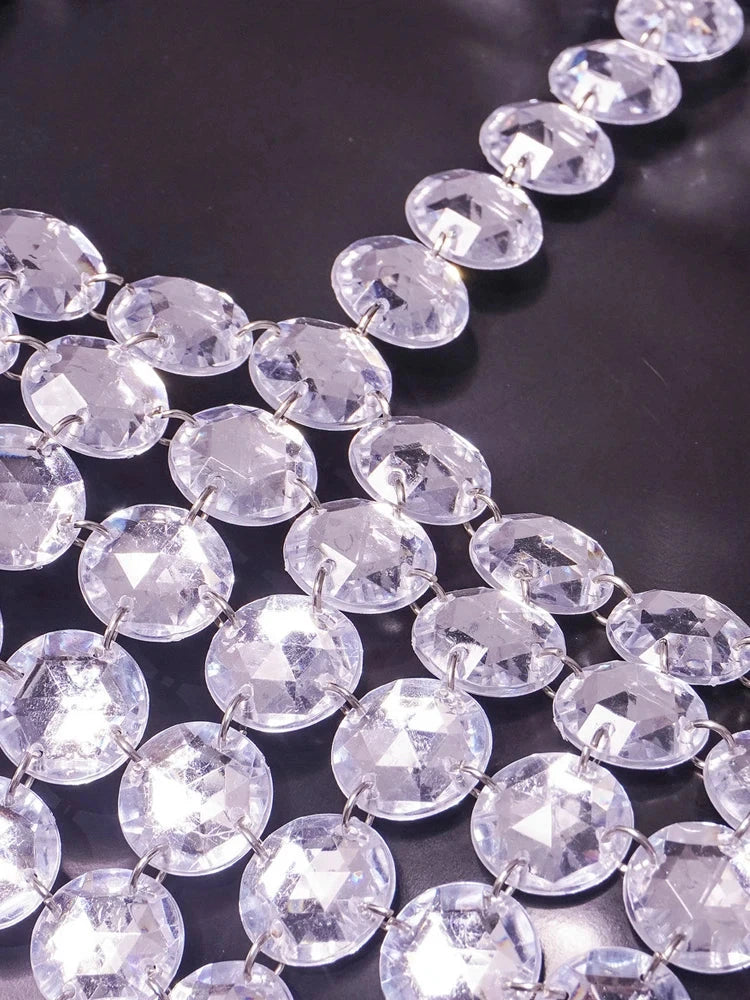 Silver halter tank top with glittering sequin detail and backless design, perfect for clubwear and festive occasions.