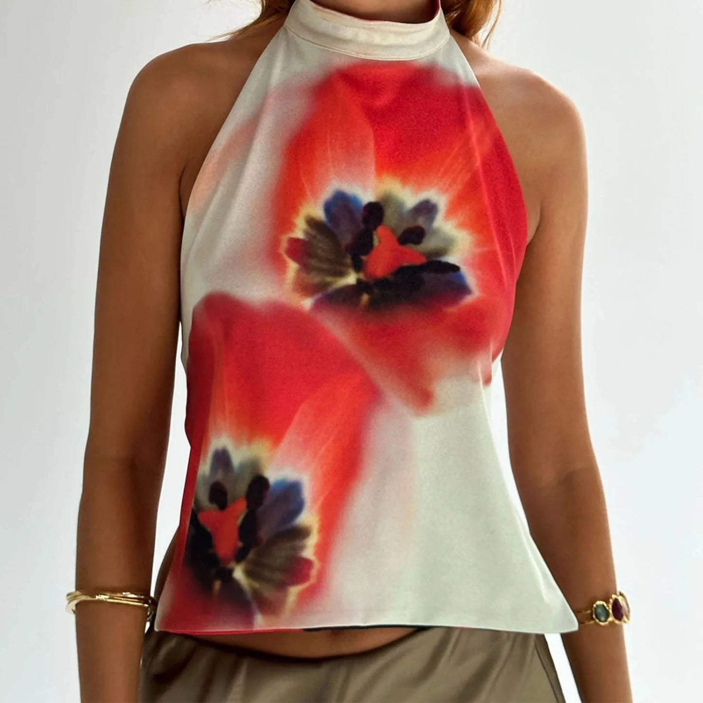 Elegant sleeveless halter top with a polka dot print, made from a cotton and polyester blend. Regular length and slight stret