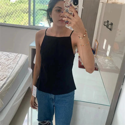 Elegant backless crop top in classic black with delicate straps and lightweight polyester fabric. Ideal for evening wear.