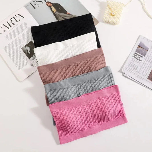 Seamless ribbed bandeau top with a flexible fit, crafted from a nylon and spandex blend. Ideal for layering or solo wear.