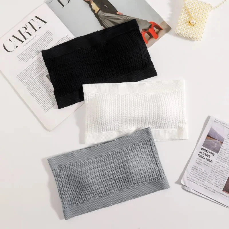 Seamless ribbed bandeau top with a flexible fit, crafted from a nylon and spandex blend. Ideal for layering or solo wear.