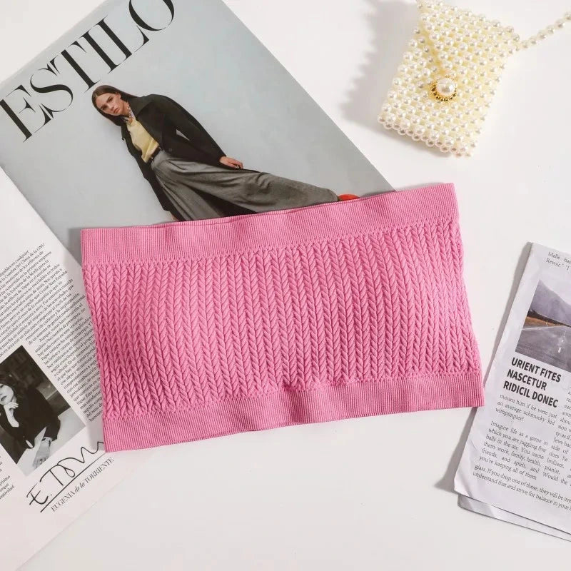 Soft pink seamless ribbed bandeau top with a flexible fit and strapless design, ideal for layering or solo wear.