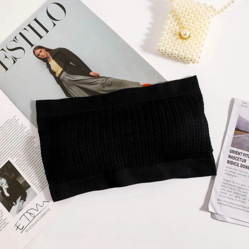 Deep black seamless ribbed bandeau top with a flexible fit and strapless design, made from a nylon and spandex blend.