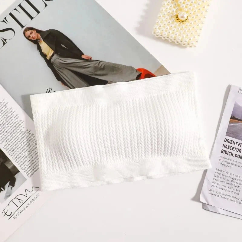 Bright white seamless ribbed bandeau top with a flexible fit and strapless design, made from a nylon and spandex blend.